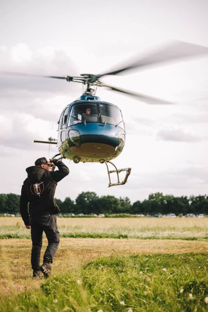 Décollage d'un hélicoptère touristique dans un champ en France avec pilote au sol