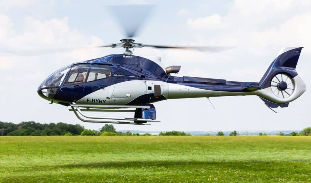 Hélicoptère bleu France Copter en vol stationnaire vu de côté